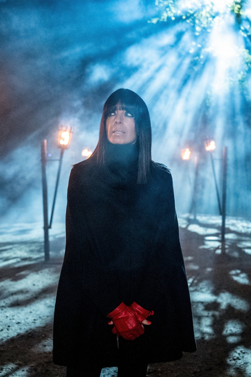 Claudia Winkleman in black cape and red fingerless gloves for The Traitors
