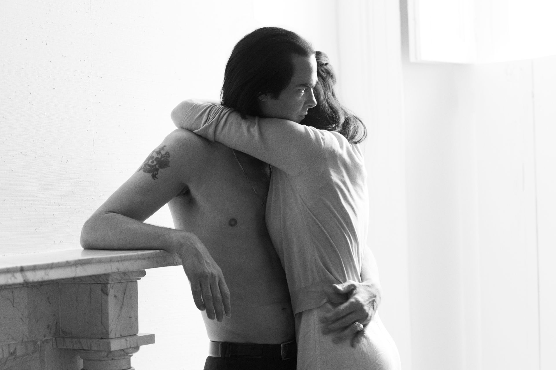 Susie embracing shirtless Nick Cave
