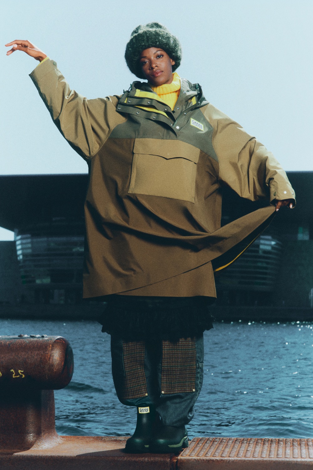 Model wearing oversized poncho from GANNI x Hunter collection