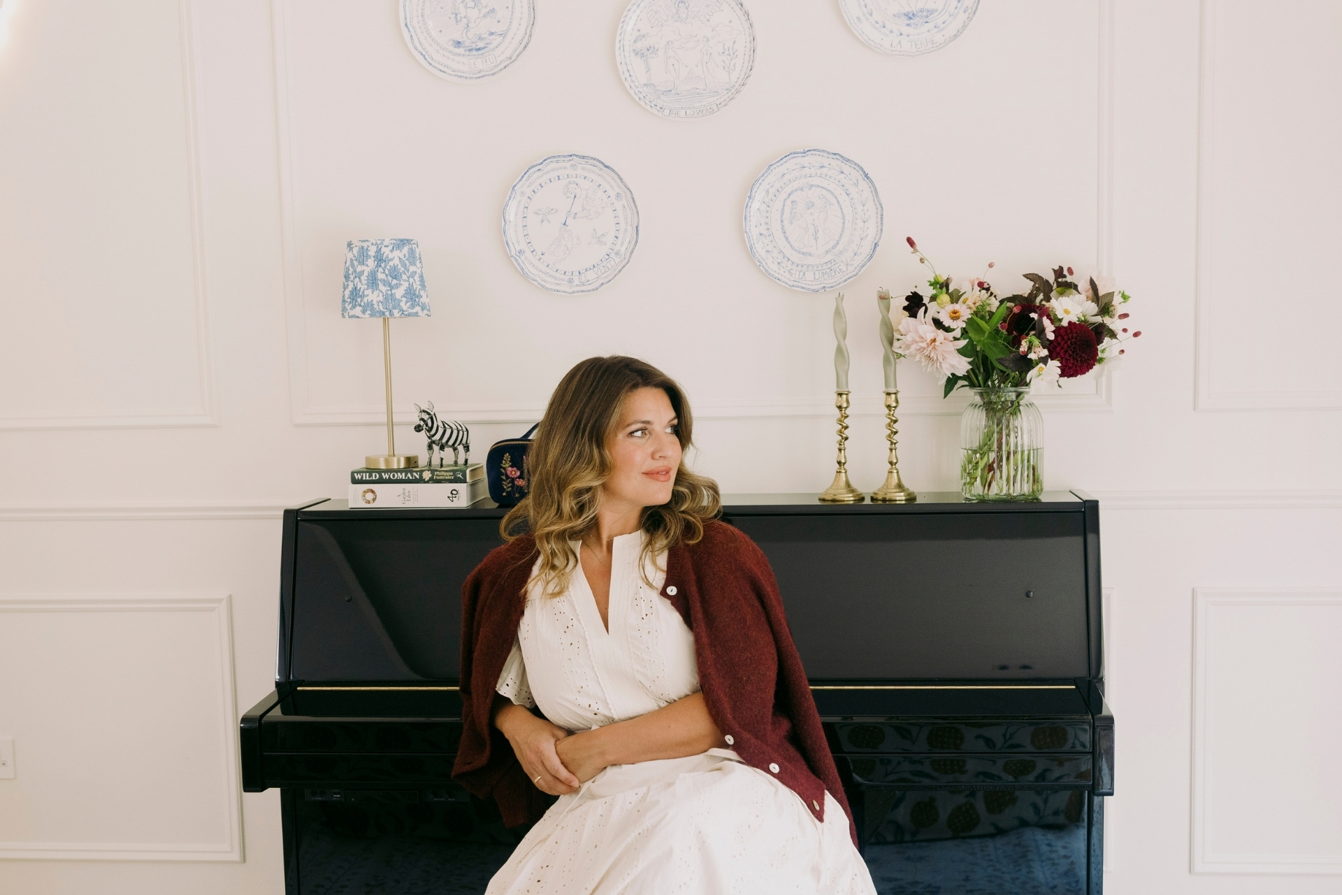 Elizabeth Petrides with piano and plates on the wall
