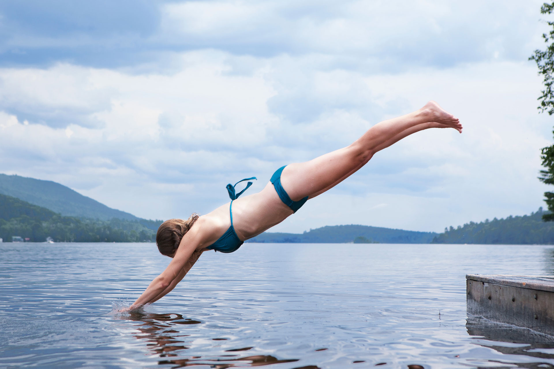 A woman jumping into a lake