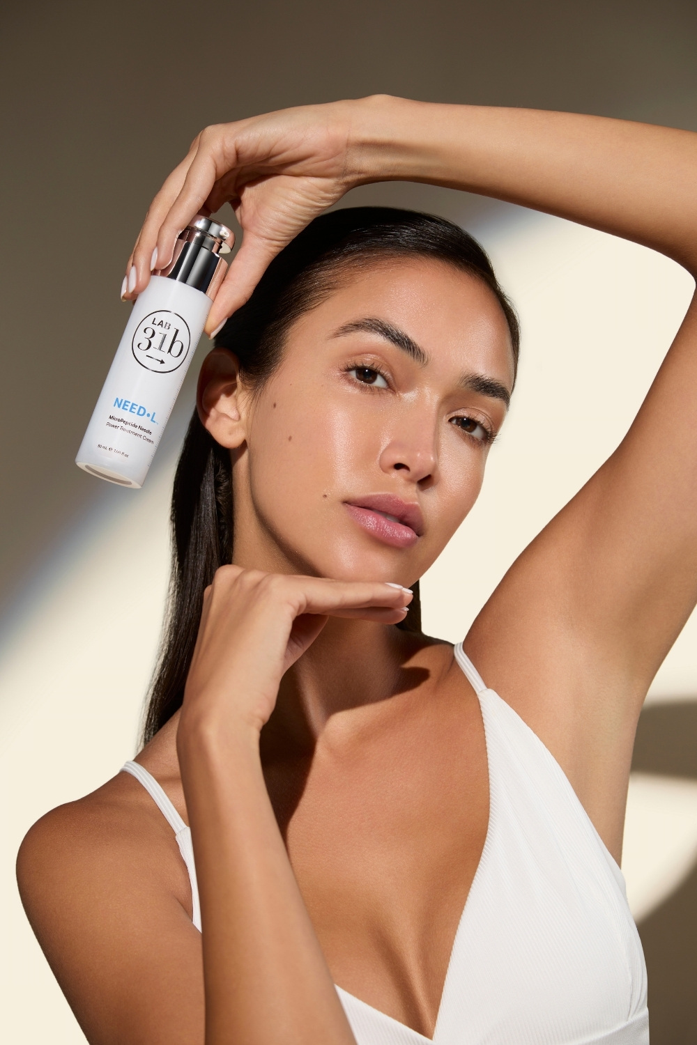 Woman holding LAB31b NEED•L MicroPeptide Needle Power Serum